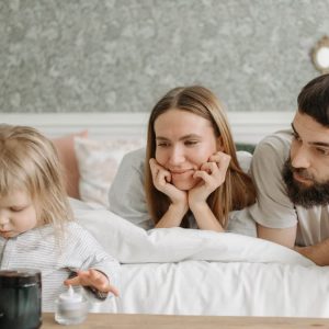 A loving family of three enjoying time together in a peaceful bedroom setting.